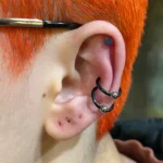 Conch piercing at Titan Piercing Montreal. The image features a stylish conch piercing located in the inner cartilage of the ear, showcasing the studio's expertise in performing precise and fashionable ear piercings.